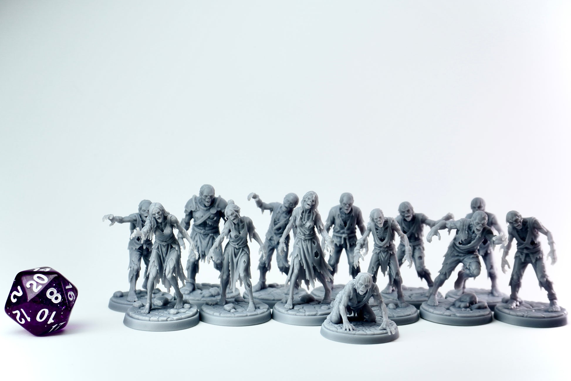 Gray zombie horde figurines with a purple dice on a white background