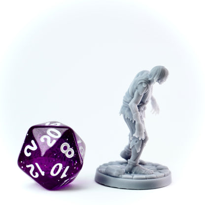 Gray figurine of a zombie creature next to a large purple polyhedral dice on a white background