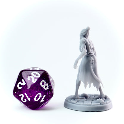 Grey zombie figurine and purple polyhedral dice on a white background