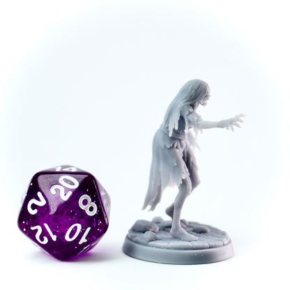 Gray figurine of a ghost-like creature next to a purple polyhedral dice on a white background